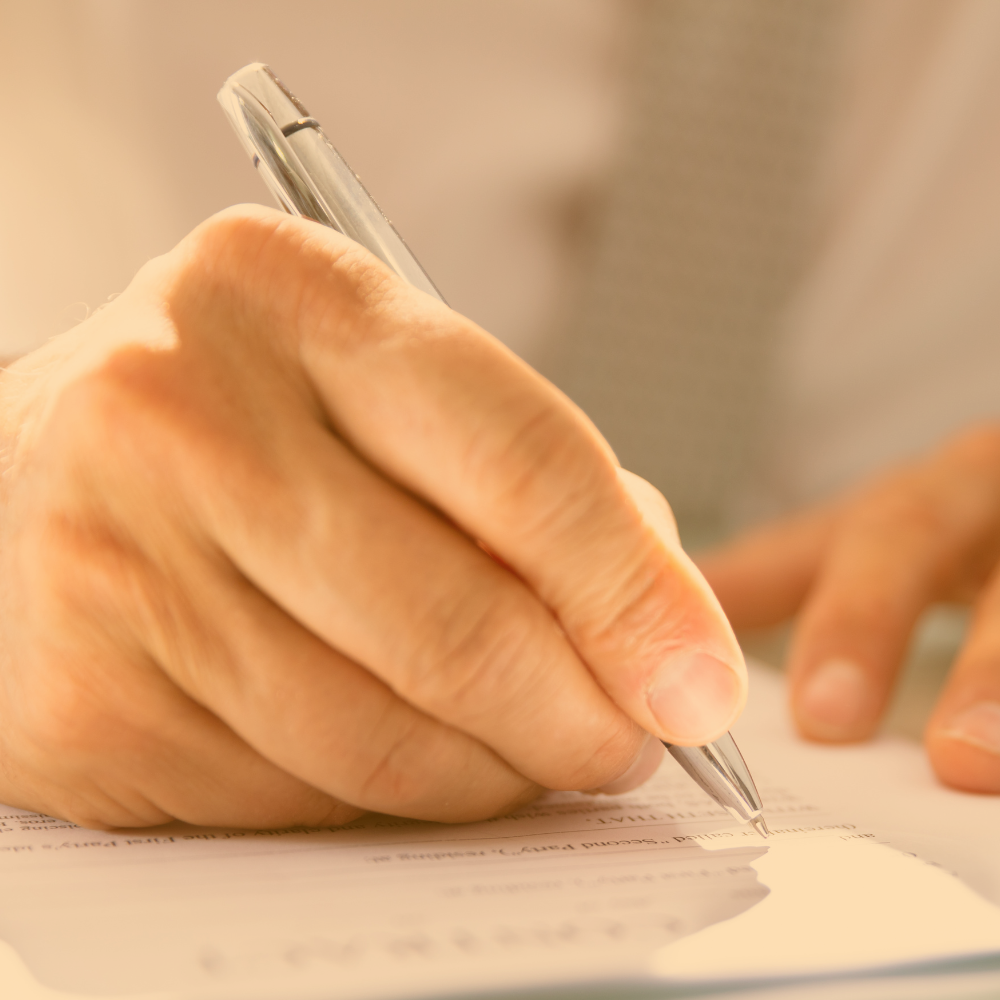 Person writing on a document