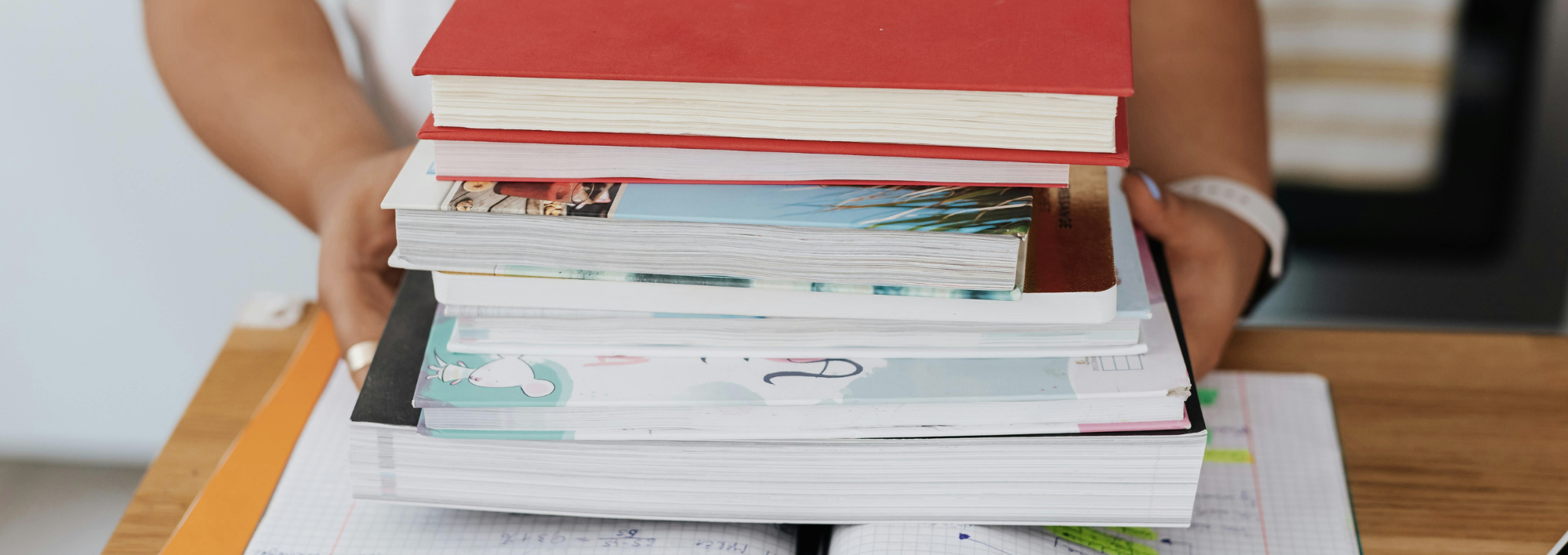 person holding a pile of books
